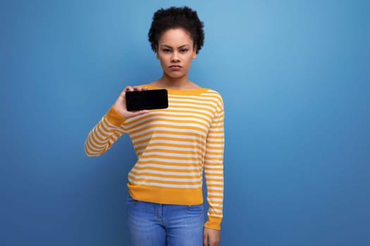 pretty latin young woman holding smartphone with mockup.