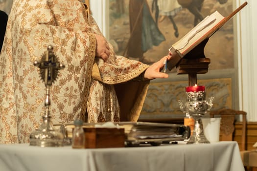A priest in a cassock prays and reads a bible