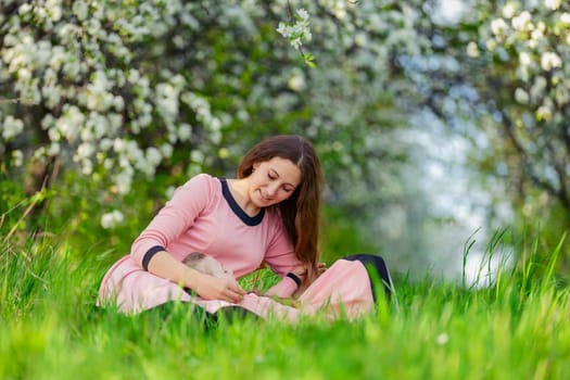 mother and daughter sit outdoors in a blooming garden