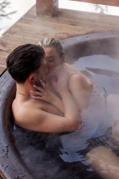 young couple hugging while sitting in a big tub of water