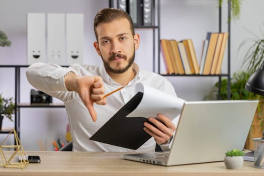 Business man reading business contract, planning project, analyzing resume, shakes finger, saying No, unsatisfied disagree, candidate with failure at office looking at camera talking, online interview