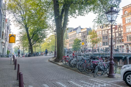 Netherlands. Summer morning on the Amsterdam Canal. Many bicycles are parked on the bridge and embankment