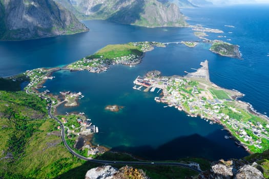 Amazing view from Reinebringen view point. Mountains and blue sea at Lofoten islands. Scenery of Reine fishing village. One of most popular hiking trails in North of Norway.