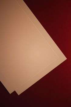 Blank A4 paper, beige on dark red background as office stationery flatlay, luxury branding flat lay and brand identity design for mockups