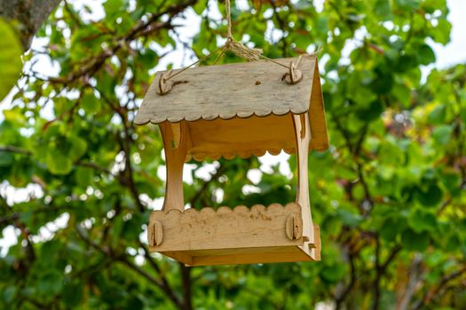 Wooden bird feeders on a blurry background of trees.