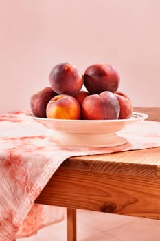 Ripe fruit of peaches in plate  on wooden table , 