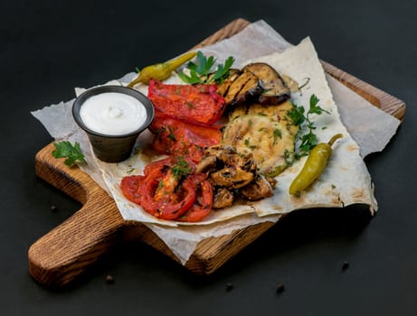 Vegan cuisine: grilled mixed vegetables on a wooden cutting board