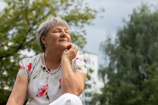 Portrait Of Real Senior Caucasian Woman With Silver Hair Sits In Park With Closed Eyes, Pleased Relaxed 70 Yo Mature Female Enjoys Time, Retirement. Healthcare Lifestyle, Wellness Of Elderly Lady