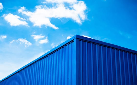 Blue warehouse roof with sky and clouds background