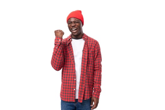 smart young african man in red plaid shirt pointing with index finger at idea over isolated white background.