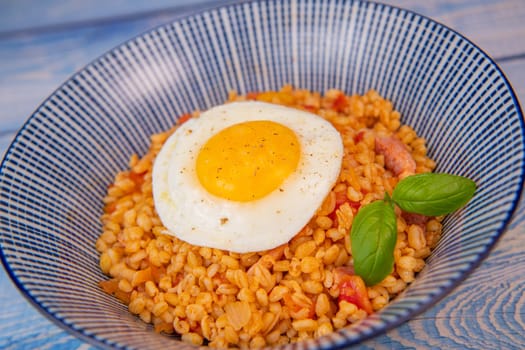 RECIPE FOR BLE WITH BACON, TOMATO AND SHALLOTS, SERVED WITH FRIED EGG. High quality photo