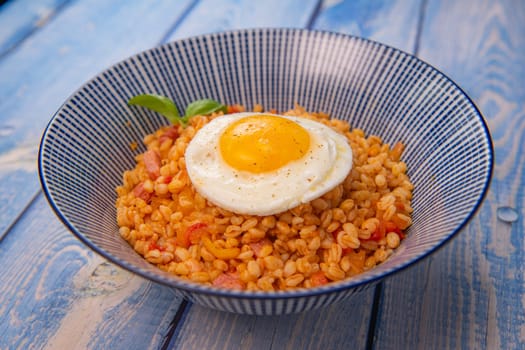 RECIPE FOR BLE WITH BACON, TOMATO AND SHALLOTS, SERVED WITH FRIED EGG. High quality photo