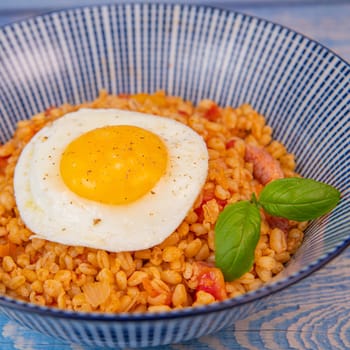 RECIPE FOR BLE WITH BACON, TOMATO AND SHALLOTS, SERVED WITH FRIED EGG. High quality photo