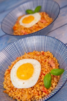 RECIPE FOR BLE WITH BACON, TOMATO AND SHALLOTS, SERVED WITH FRIED EGG. High quality photo