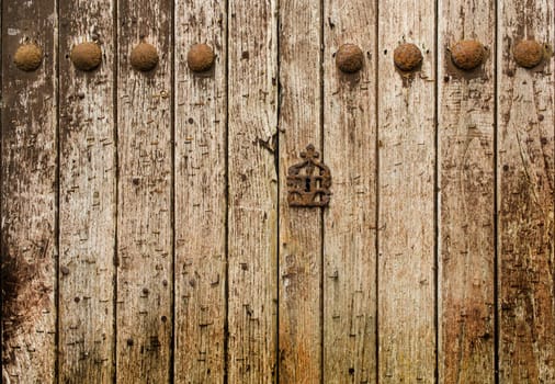 Very old wooden door with a lot of texture and rusty iron nails.