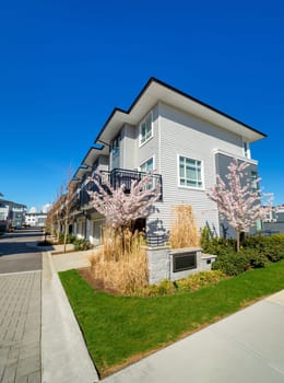 Row of residential townhouses on bright sunny day with blue sky background