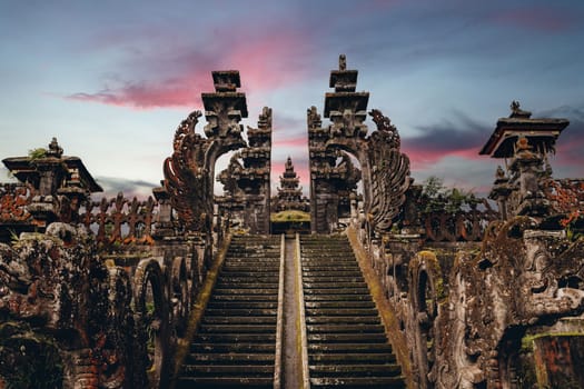 Landscape view of sacred Besakih temple with sunset sky background. Stone ladder to holy religious praying place