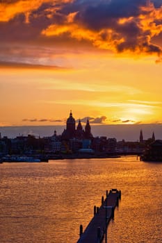 Amsterdam cityscape skyline with Church of Saint Nicholas (Sint-Nicolaaskerk) on sunset with dramatic sky. Amsterdam, Netherlands