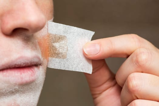 Depilation excess hair over the lips, a woman applied a special patch with wax to the mustache. Hair removal, wax depilation at home, beauty treatment concept.