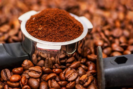 Freshly ground coffee in a metal filter on background coffee beans. Espresso filter holder for coffee machine with ground coffee.