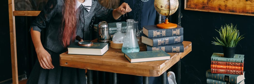 Schoolgirl perform chemical experiments. Flasks with solutions and chemical formulas on the blackboard in the school classroom. Back to school. School and preschool education.