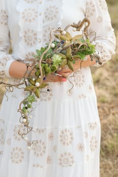 The bride holds an unusual braided wedding bouquet in her hands.