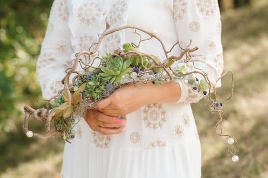 The bride holds an unusual braided wedding bouquet in her hands.