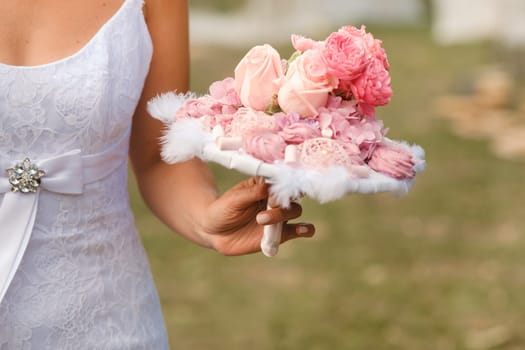 The bride holds her wedding bouquet in her hands.