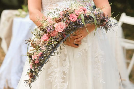 The bride holds her wedding bouquet in her hands.