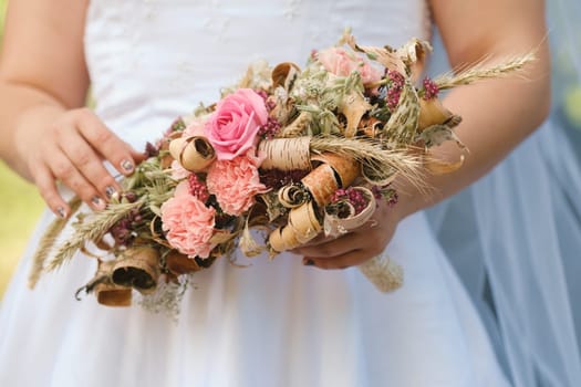 The bride holds her wedding bouquet in her hands.