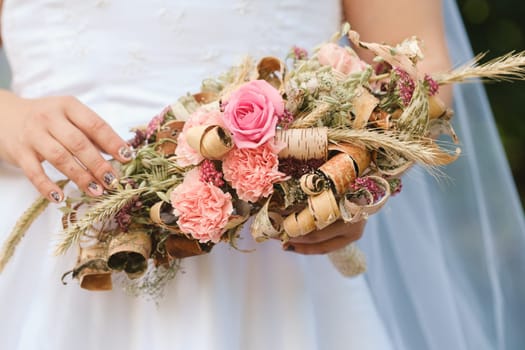 The bride holds her wedding bouquet in her hands.