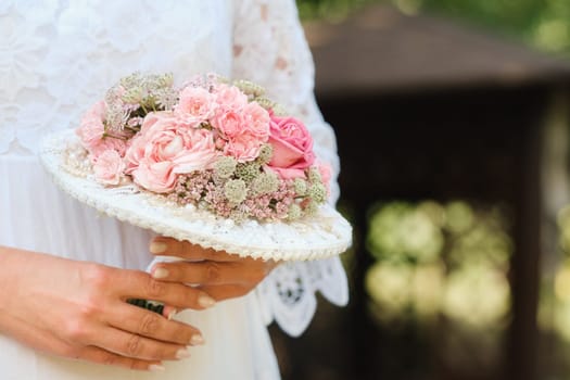 The bride holds her wedding bouquet in her hands.