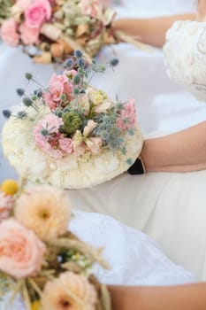 The bride holds her wedding bouquet in her hands.