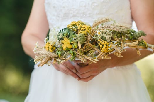 The bride holds her wedding bouquet in her hands.