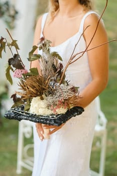 The bride holds her wedding bouquet in her hands.