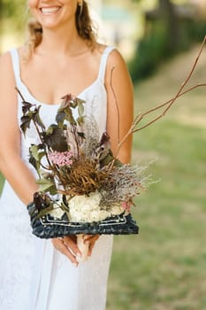 The bride holds her wedding bouquet in her hands.