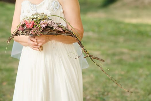 The bride holds her wedding bouquet in her hands.