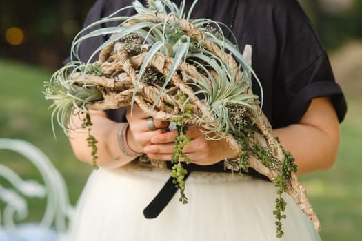 The bride holds her wedding bouquet in her hands.