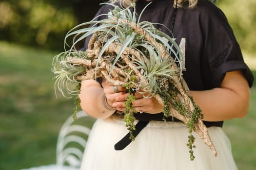 The bride holds her wedding bouquet in her hands.