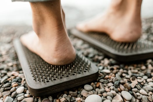 Sea Woman feet stepping on sadhu board during indian practice on the seashore. . Healthy lifestyle concept. tool for working out your inner state.