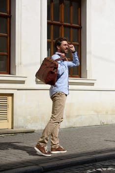 Handsome businessman walking on the street, with luxury leather briefcase. Fashionable style. Street photo