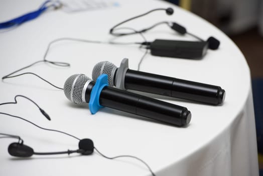 two microphones on a round table. white tablecloth