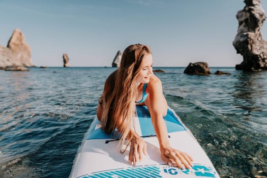 Close up shot of happy young caucasian woman looking at camera and smiling. Cute woman portrait in bikini posing on a volcanic rock high above the sea