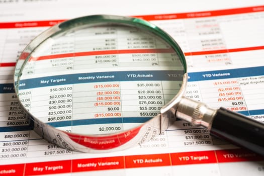 Magnifying glass on spreadsheet and graph paper. Financial, Banking Account, data economy, Business concept.