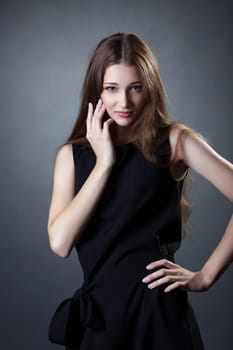 Portrait of pretty young girl posing in trendy black dress