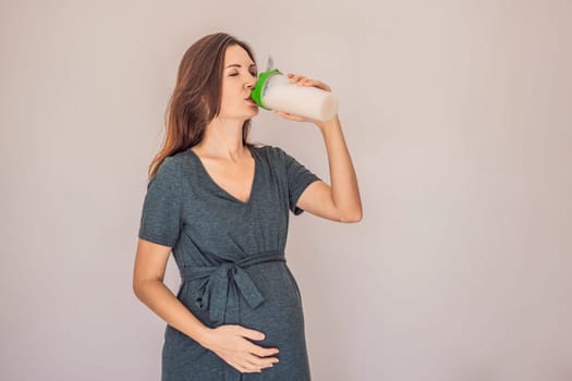 Energetic and fit pregnant woman after 40 enjoying a protein shake for a nourishing boost during her pregnancy journey. Embracing health and wellness for a thriving baby and mom.