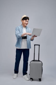 Young asian traveller man holding a laptop