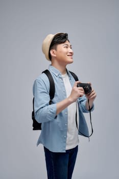 Full-length photo of young handsome man tourist with camera and retro camera in hands