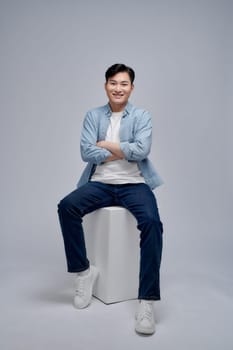 Young Asian man sitting on background