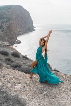 Woman sea green dress. Side view a happy woman with long hair in a long mint dress posing on a beach with calm sea bokeh lights on sunny day. Girl on the nature on blue sky background